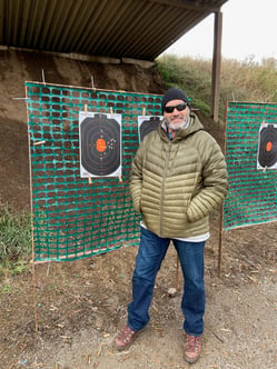 Bruce standing in front of a target at a gun range