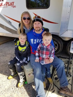 Nic Weiler and his family sitting on a cooler