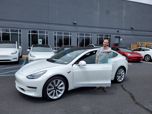Nick Baumann in the door of a Tesla Model 3