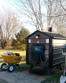 Smoker with a wheel barrow full of wood